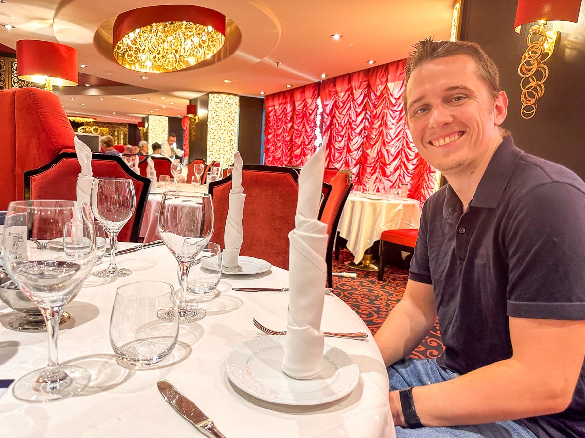the author's husband sitting in the fine dining restaurnat at villa rossa on the msc divina