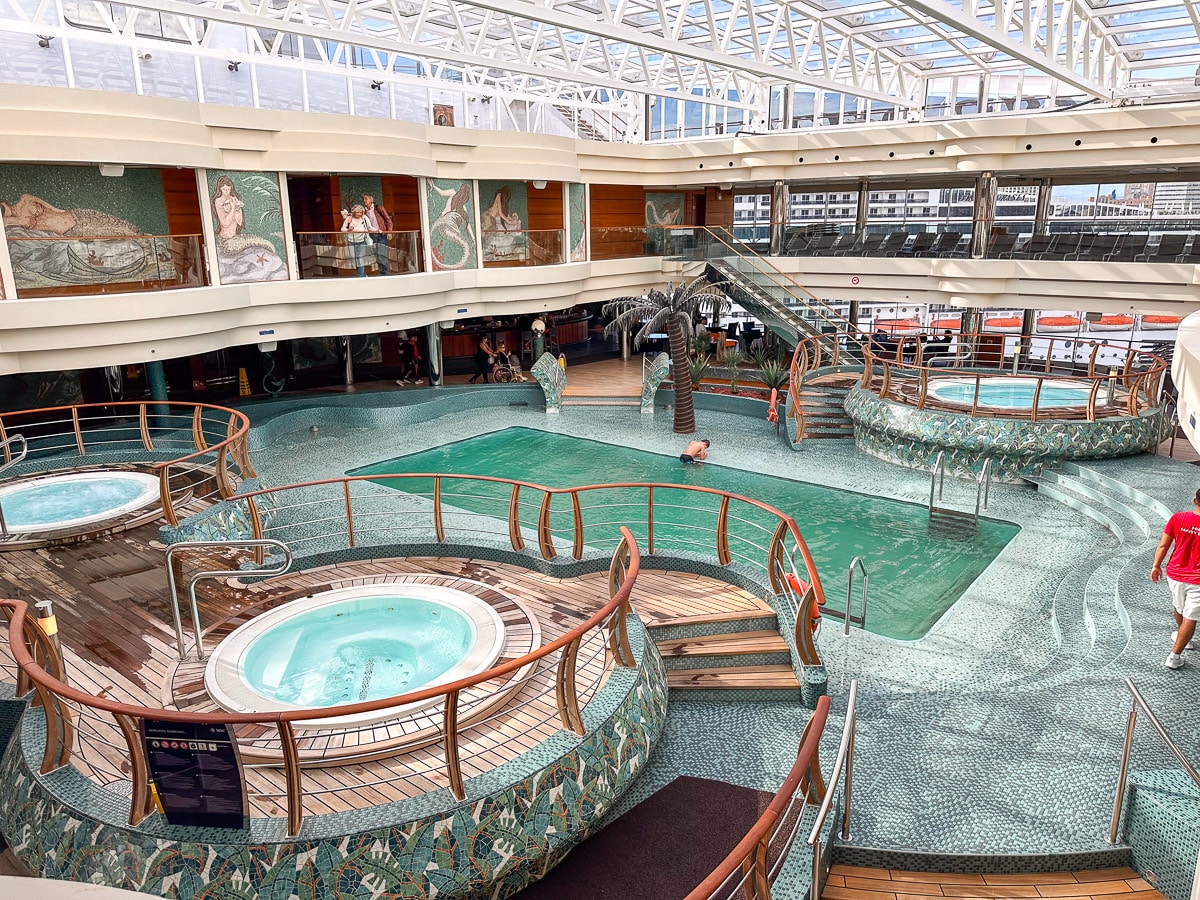 the pool area on the indoor part of the msc divina with a pool and three hot tubs