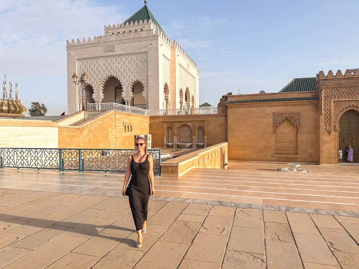 the author walking in a black dress in front of the mausoleum of mohammed v in rabat