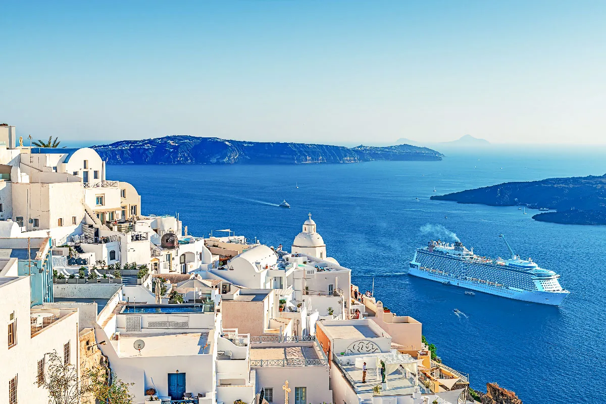 stunning picture of the santorini cruise port with a cruise ship sending tender boats towards the island