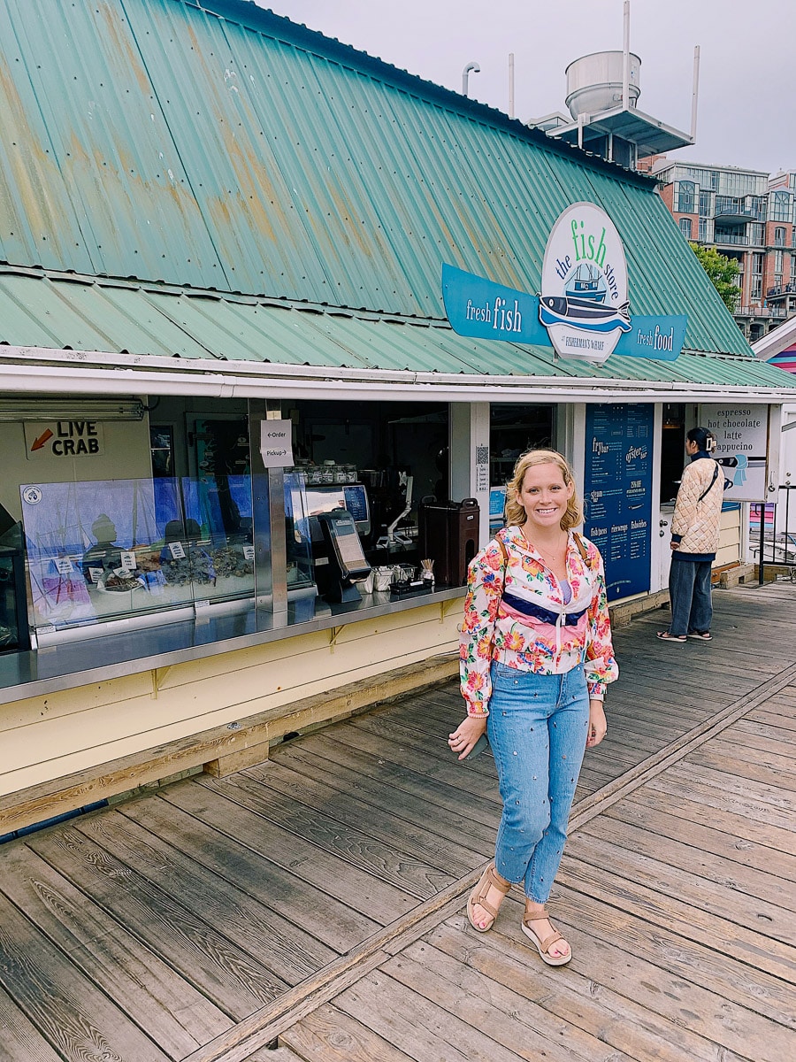 the author's friend posing in front of a fish store in canada 