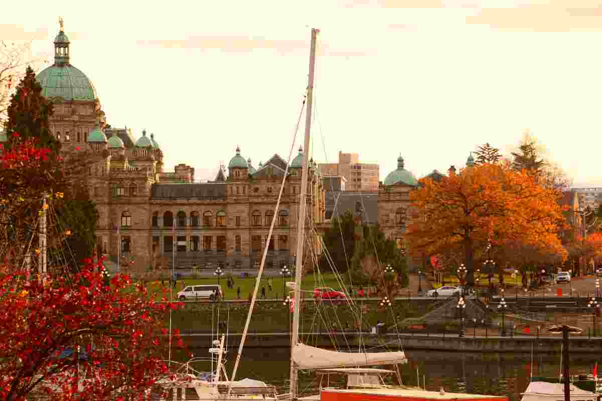 stunning capitol building of victoria bc in fall with fall foliage and boats in front