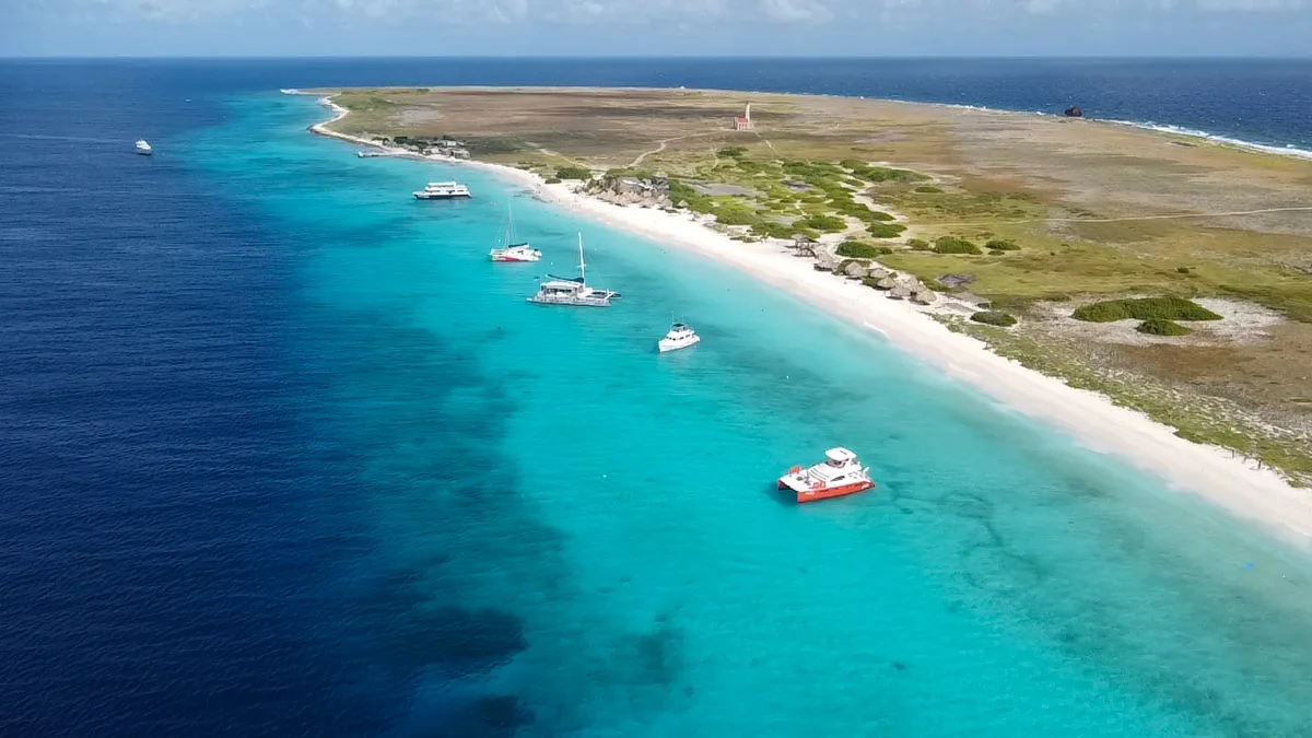 klein curacao boat trips with lots of boats lines up on a white sandy beach