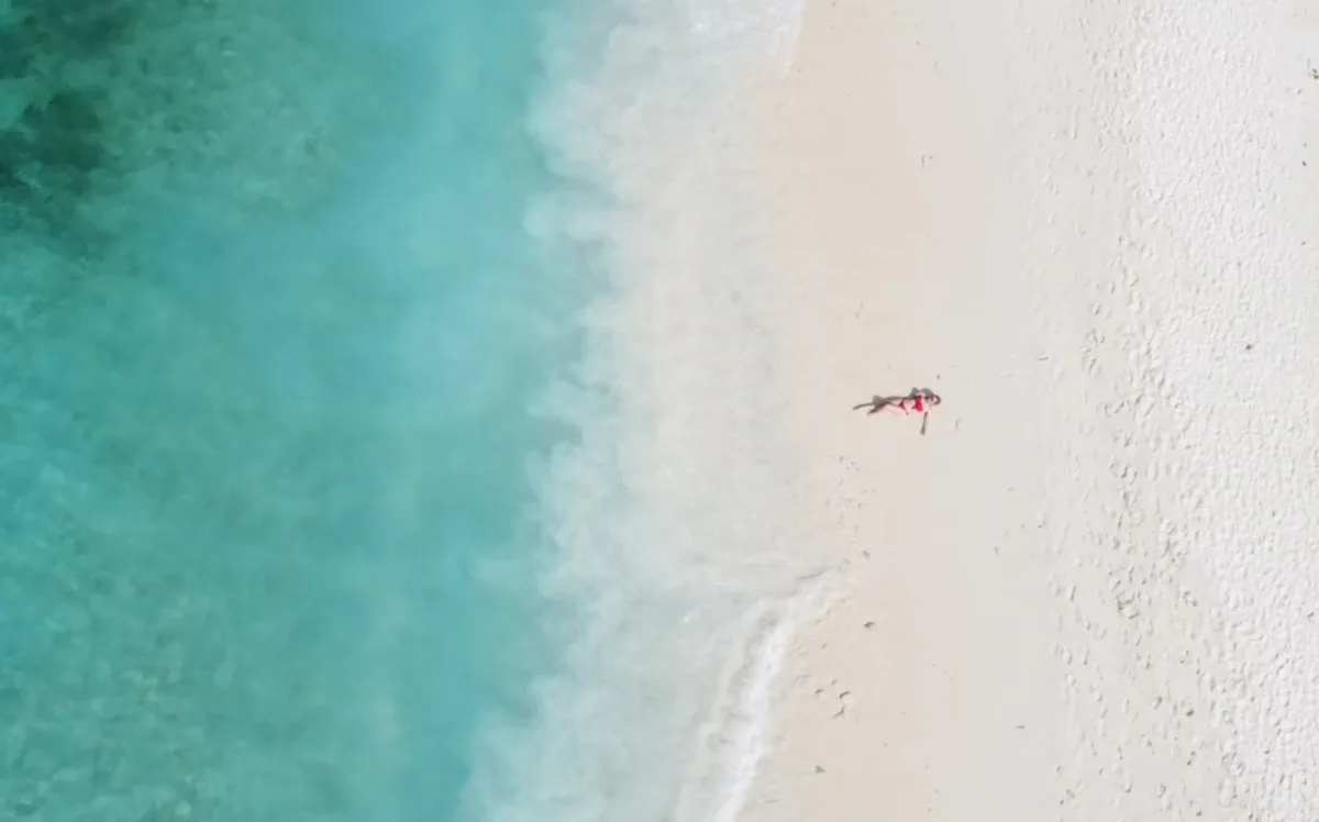 the author lying on klein beach in klein curacao at a boat trip, amazing shot taken from above