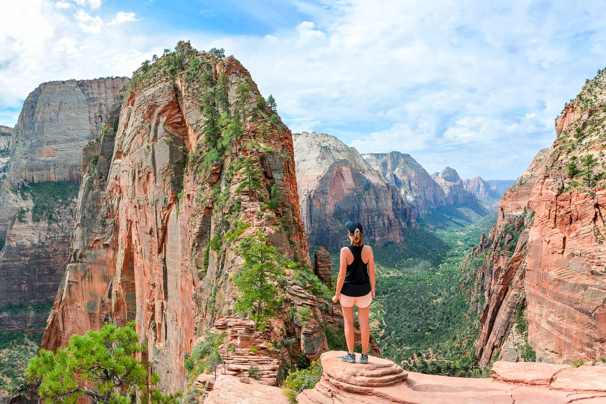 girl standing in front of a beautiful big arch in a national park that needs to be on everyones us bucket list
