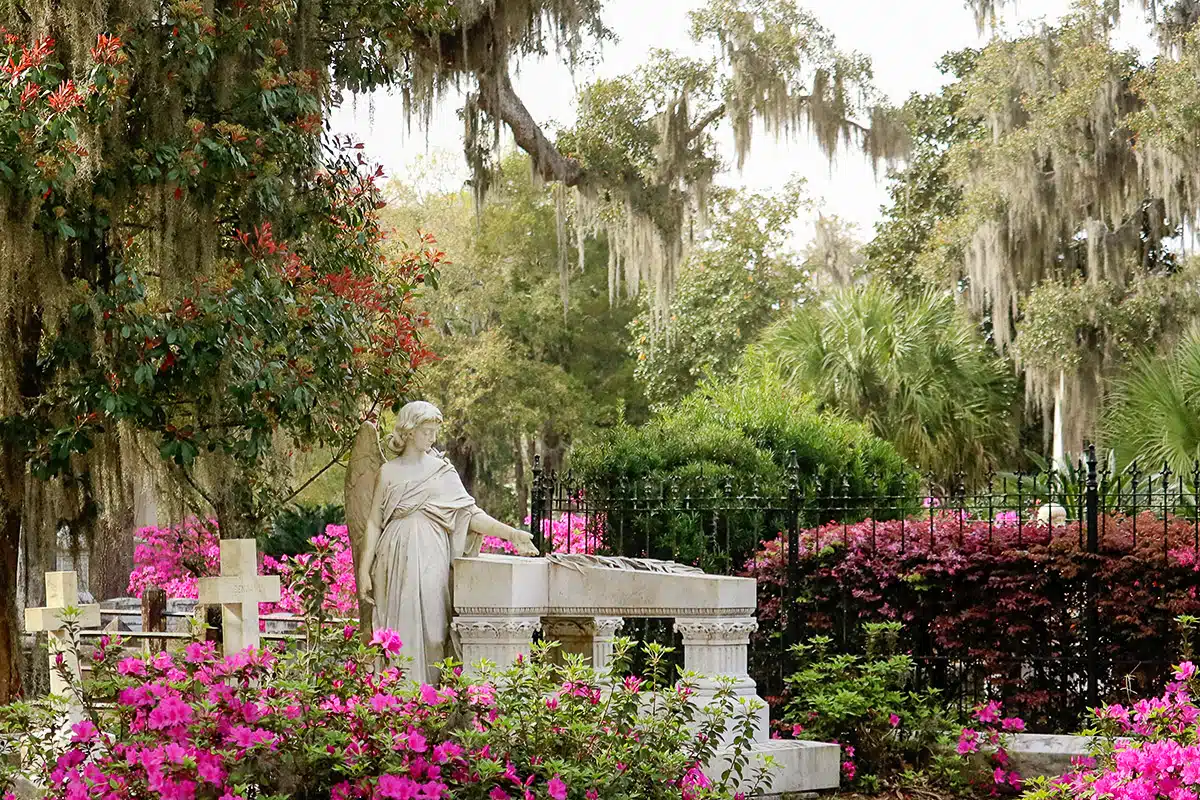 statue in a park on a cemetary in savannah with flowers