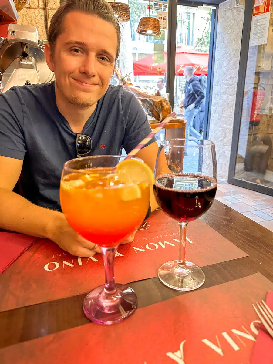 the authors husband enjoying a glass of red wine and sangria in barcelona