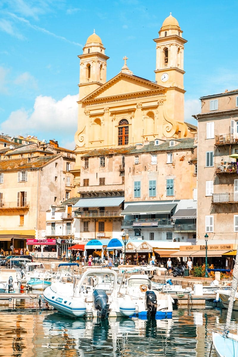 BASTIA, FRANCE - SEPTEMBER 16, 2018: A view of the Vieux Port, the Old Port of Bastia, in Corsica, France, highlighting the Saint-Jean-Baptiste Church with its characteristic twin bell towers