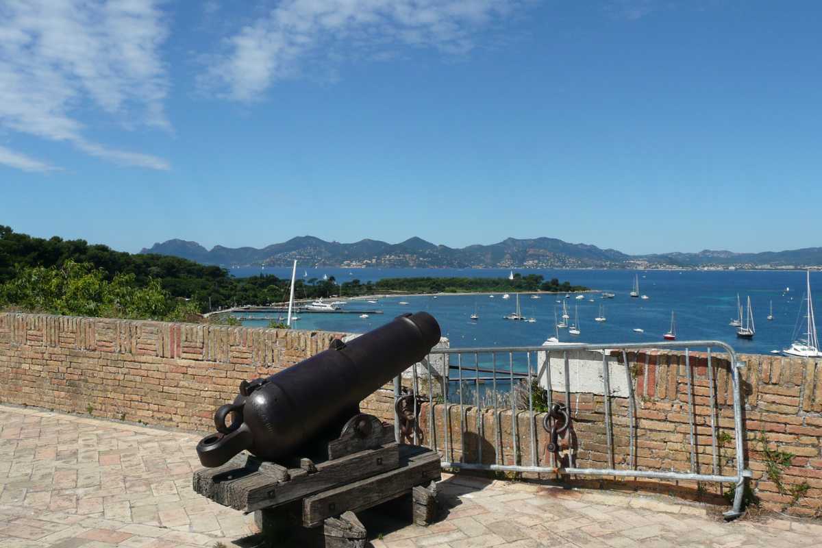 view from saint marguerite island near cannes with lots of smaller sailboats and yachts in the background and an old cannon in the center of the picture