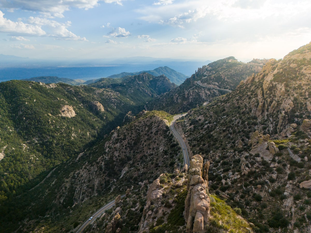 stunning drone shot of tucson and mount lemmon with a sencic highway leading through mountain areas