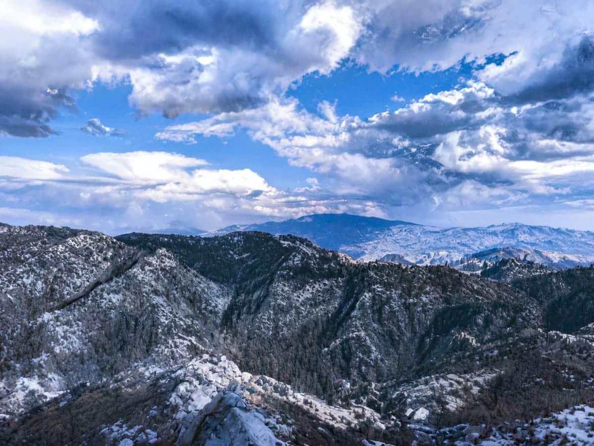Snow-capped mountain range under a bright blue sky with dramatic clouds in the Southwest USA. in Tucson Mount Lemmon in winter
