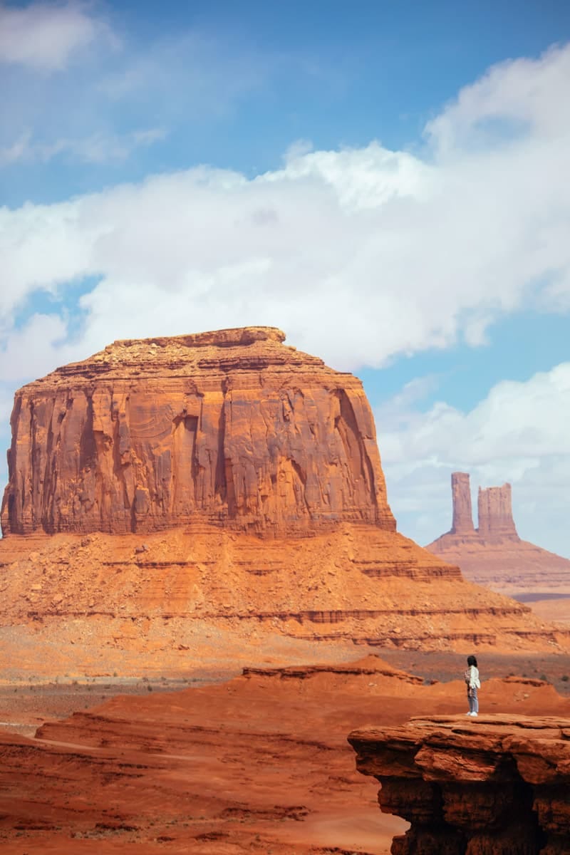 a girl standing on the edge of a cliff at john forde point