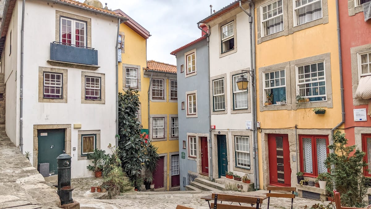 Charming houses in Porto’s Ribeira district – A quaint alley lined with colorful, historic homes, featuring traditional Portuguese architecture with wooden shutters and cobblestone streets.