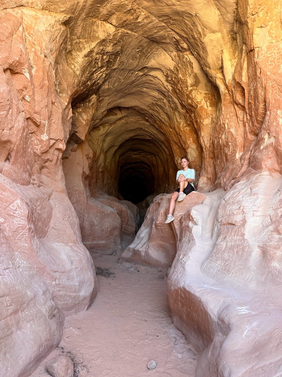 the author's wife sitting inside the dragon's belly hiking trail in kanab