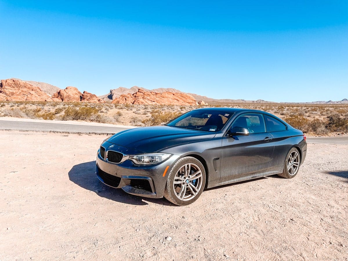 a stunning picture of a bmw in the red rocks canyon outside of las vegas