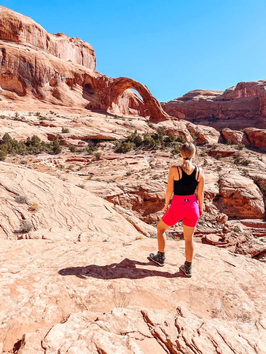 the author's wife posing in front of the corona arch in utah, moab