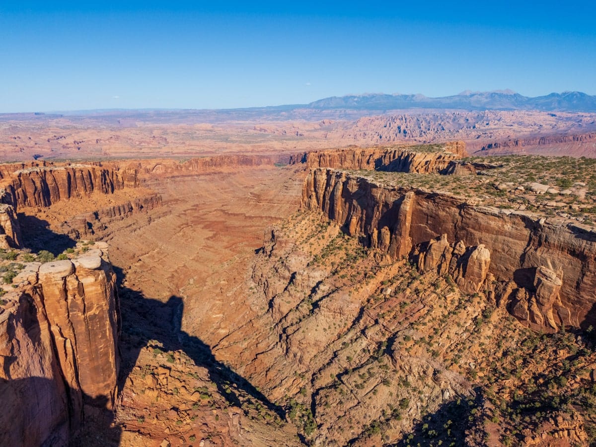 Breathtaking aerial view of Island in the Sky district in Canyonlands National Park, showing deep canyons, cliffs, and expansive desert plateaus.