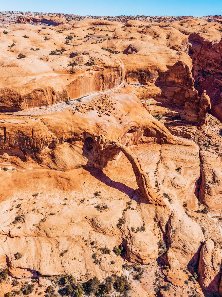 Impressive sandstone arch standing tall against a clear sky in the Utah desert landscape