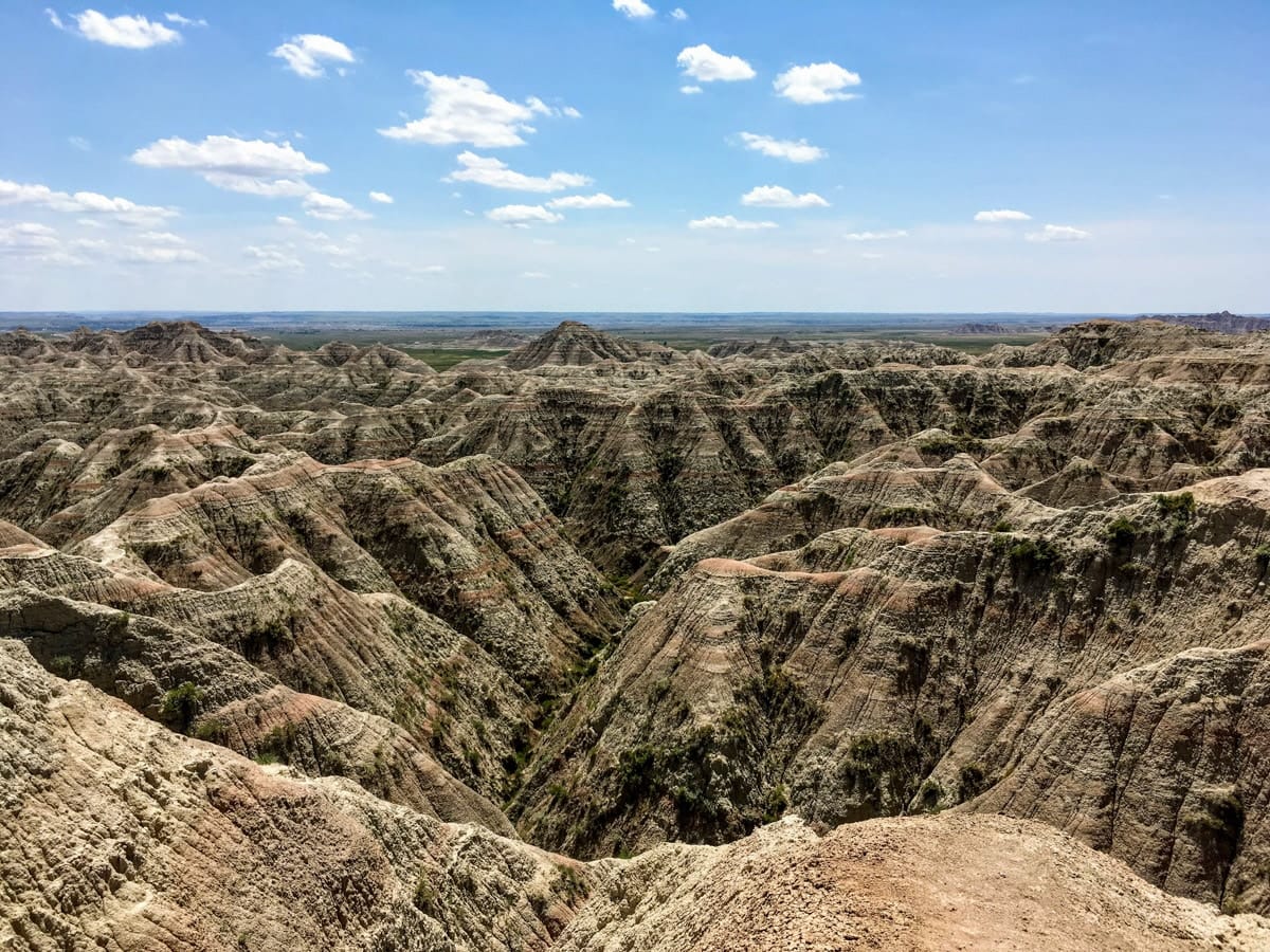 Vast panoramic view from Big Badlands Overlook in South Dakota, revealing deep canyons and rugged formations stretching to the horizon.