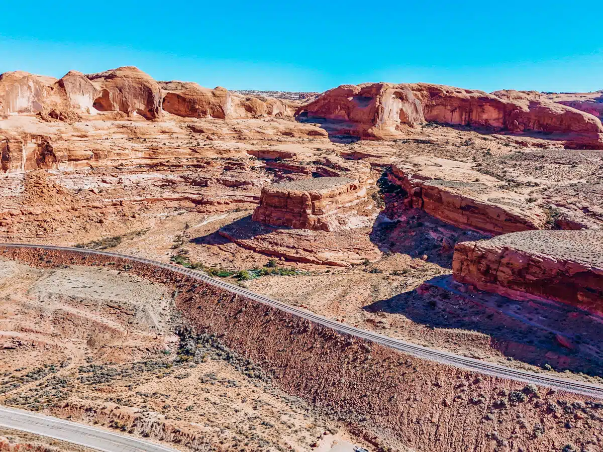 Scenic desert highway winding through layered sandstone formations in Moab, Utah