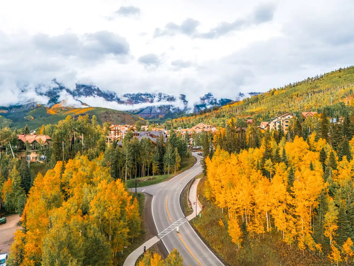 the million dollar highway in telluride with golden aspen trees on both sides