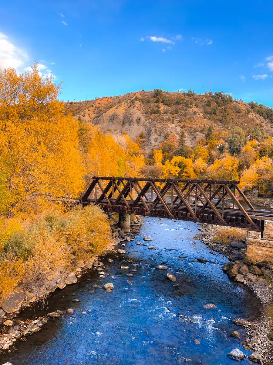 animas river in deep blue surrounded by golden and orange aspen trees
