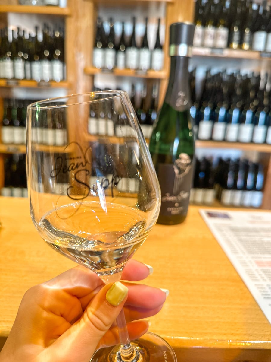 a wine tasting at domaine jean sipp in ribeauville wiht a wine glass in focus